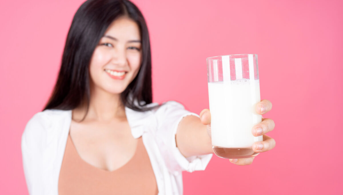 beauty woman feel happy drinking milk for good health in the morning on pink background - lifestyle beauty woman