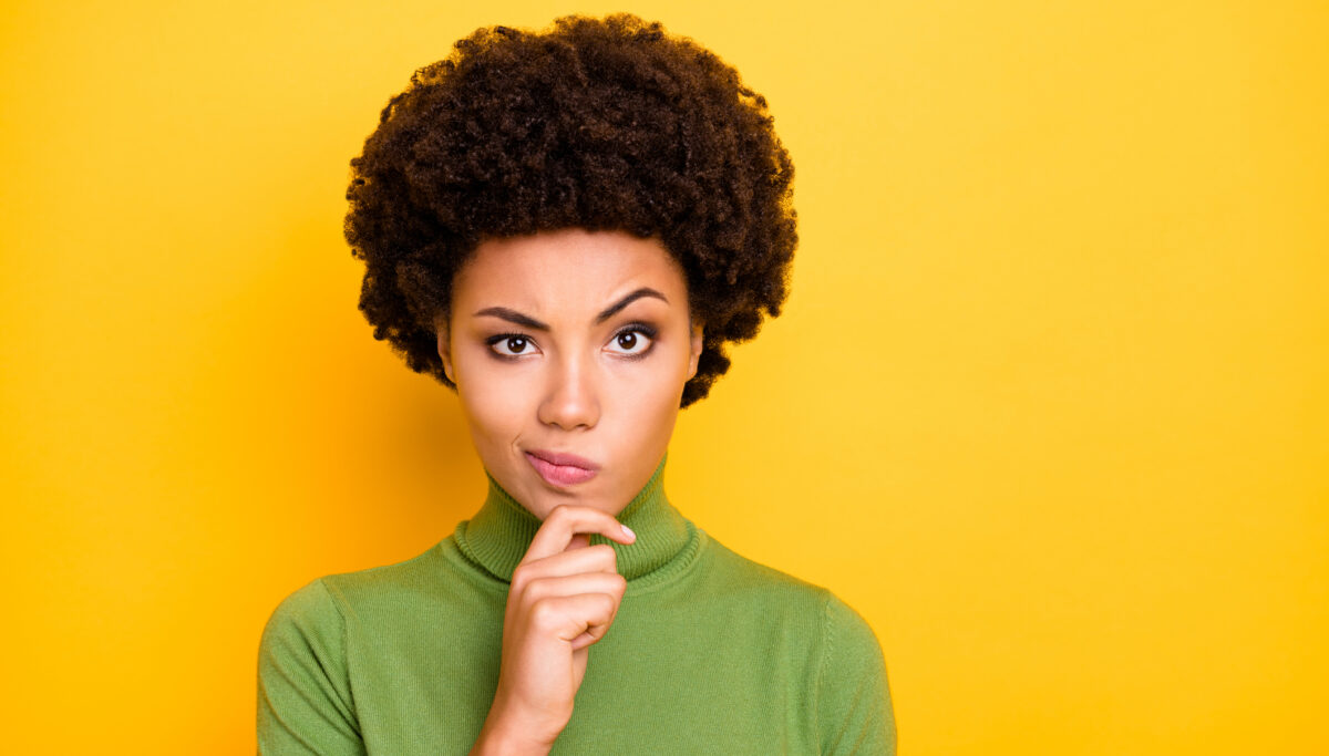 Photo of wavy brown haired interested woman grimacing touching, chin with curiosity on face isolated vivid color background