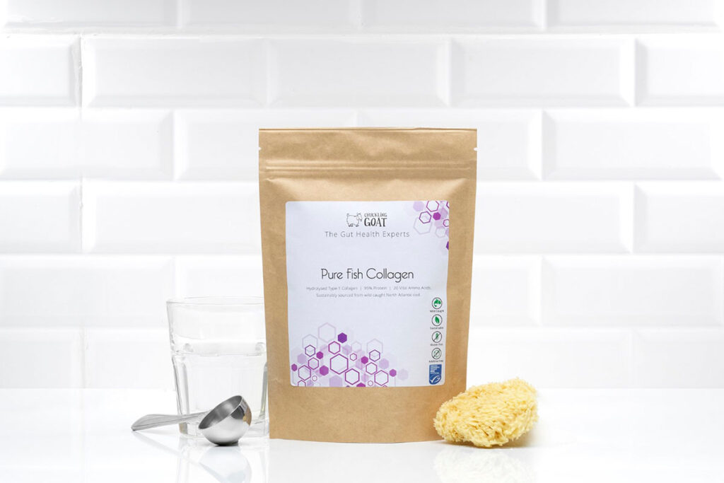 Photo of Chuckling Goat Pure Fish Collagen beside scoop and glass on white background.